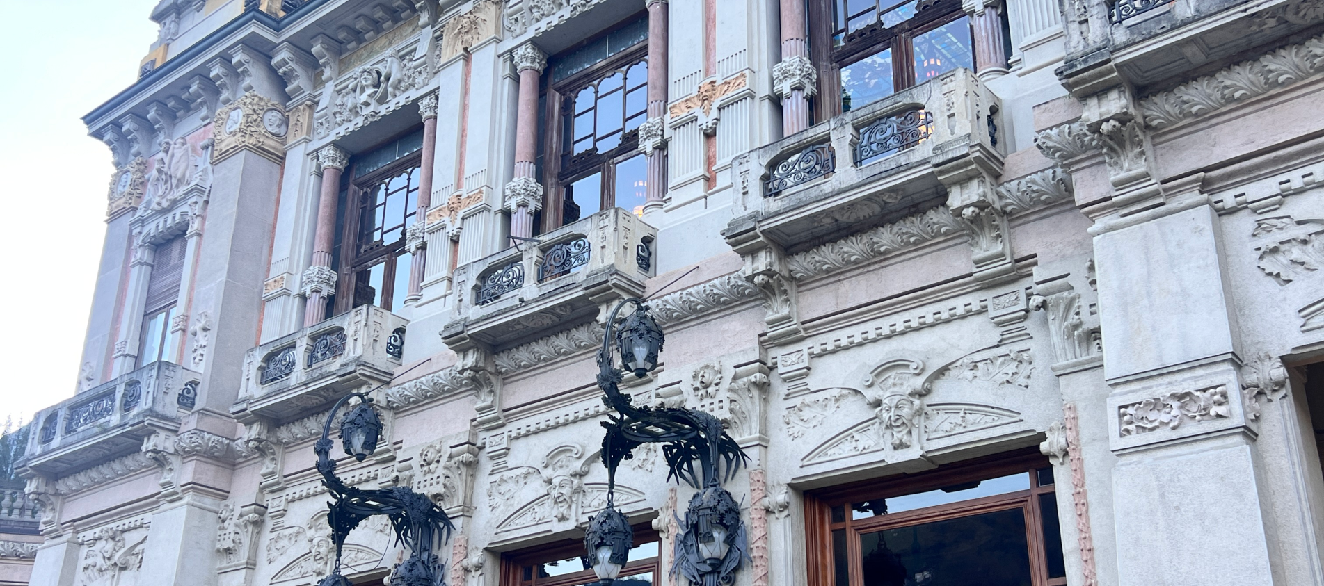 Elegant historic building with ornate architecture, tall windows, and decorative details in San Pellegrino Terme, Italy, under a clear blue sky